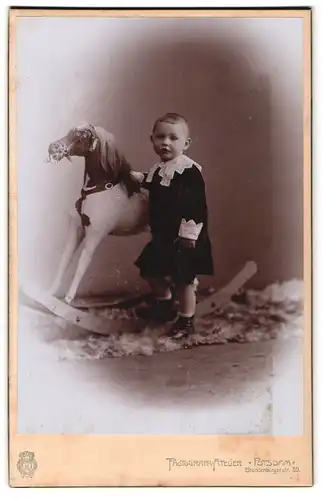 Fotografie Atelier Potsdam, Potsdam, Brandenburgerstr. 30, Portrait junger Knabe im Samtkleid mit grossem Schaukelpferd