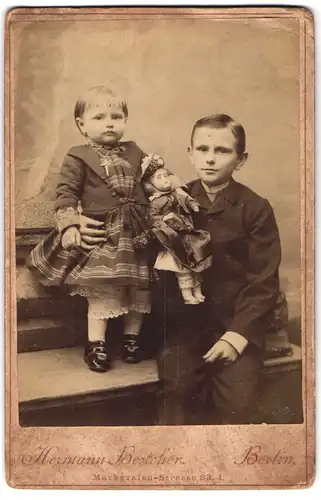 Fotografie Hermann Besteher, Berlin, Markgrafenstr. 83, Portrait zwei Kinder im Anzug und Kleid mit Puppe im Arm