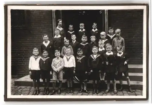 Fotografie unbekannter Fotograf und Ort, Gruppenfoto einer Schulklasse mit Knaben in Schuluniform samt Lehrerin