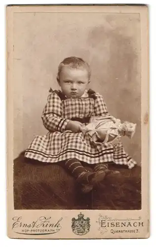 Fotografie Ernst Zink, Eisenach, Querstr. 3, Portrait kleines Mädchen im karierten Kleid mit Puppe in der Hand