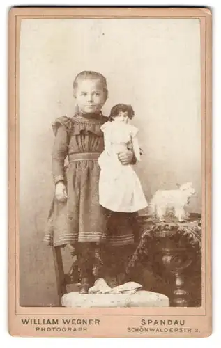 Fotografie William Wegner, Berlin, Schönwalderstr. 2, Portrait niedliches Mädchen im Kleid mit grosser Puppe im Arm