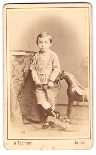 Fotografie W. Fechner, Berlin, Krausenstr. 21, Portrait junger Knabe im Anzug mit Schaukelpferd
