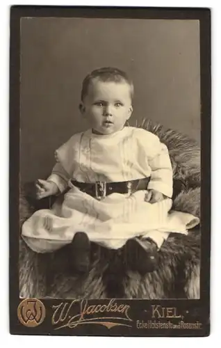 Fotografie W. Jacobsen, Kiel, Rosenstr., Portrait blondes Kleinkind im Kleidchen mit Gürtel