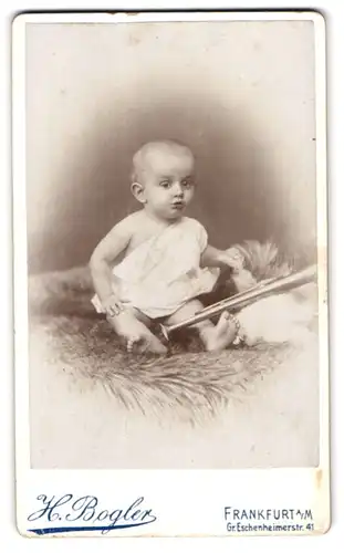 Fotografie H. Bogler, Frankfurt / Main, Gr. Eschenheimerstr. 41, Portrait süsses Baby im Hemdchen auf Fell sitzend