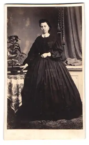 Fotografie J. Giese, Itzehoe, Portrait junge Frau im tief schwarzen Kleid mit Ohrringen
