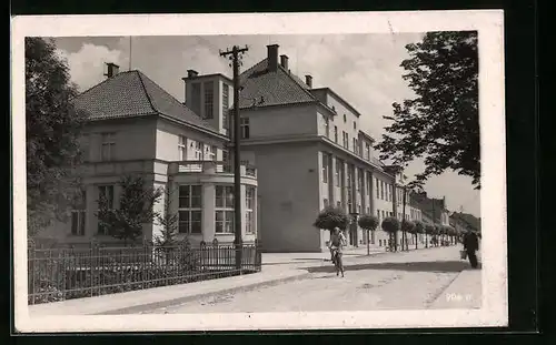 AK Blatna, Radfahrerin vor den Stadthäusern