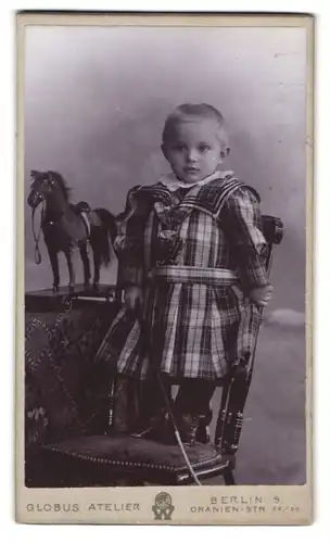 Fotografie Globus Atelier, Berlin, Oranienstr. 52 /55, Portrait niedliches blondes Mädchen im Kleid mit Spielzeug Pferd