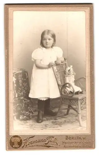 Fotografie Hermann Tietz, Berlin, Liepziger Str. 46, Portrait niedliches Mädchen im weissen Kleid mit Puppe auf dem Stuhl