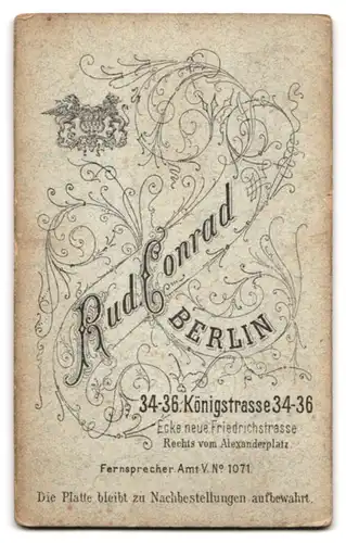 Fotografie Rud. Conrad, Berlin, Königstr. 34-36, Portrait Kleinkind im weissen Kleidchen mit grossem Schaukelpferd