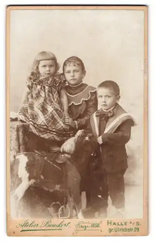 Fotografie Atelier Benckert, Halle a. S., gr. Ulrichstr. 29, Portrait drei Kinder mit ihrem Schaukelpferd im Atelier