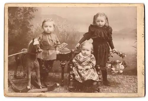 Fotografie Hugo Delling, Meissen, Portrait süsse Kinder mit Schaukelpferd und Blumenkorb im Atelier