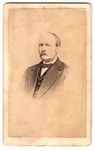 Fotografie R. Ström, Husum, Portrait friesischer Herr im Anzug mit Moustache und Halbglatze