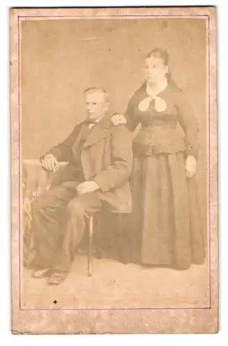 Fotografie unbekannter Fotograf und Ort, Portrait Paar im Biedermeierkleid und Anzug posieren im Atelier