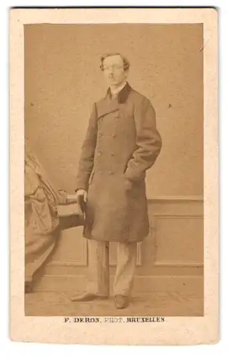 Fotografie F. Deron, Bruxelles, Portrait Herr im Anzugsmantel mit Zylinder in der Hand