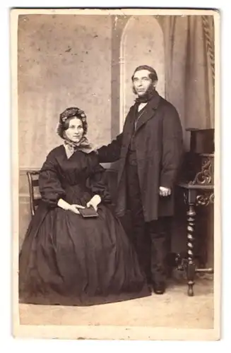 Fotografie George Hornemann, Rostock, Hopfenmarkt 13, Portrait älteres Ehepaar im dunklen Kleid mit Haube