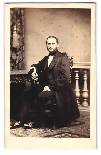 Fotografie F. Baechler, Weissenfels, Portrait Herr im dunklen Anzug mit Flanierstock sitzend im Atelier