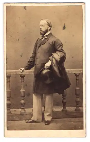Fotografie unbekannter Fotograf und Ort, Portrait älterer Herr im Anzug mit Zylinder und Mantel über dem Arm