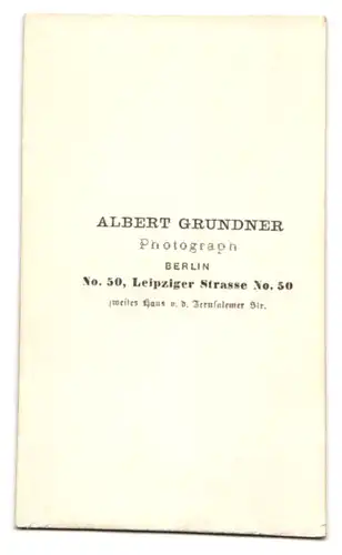 Fotografie Albert Grundner, Berlin, Leipzigerstr. 50, Portrait junger Knabe im hellen Anzug mit Mütze auf dem Tisch