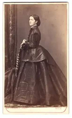 Fotografie Ferret, Nice, Rue Gioffredo, Portrait junge Dame im marmorierten Kleid stehend am Stuhl
