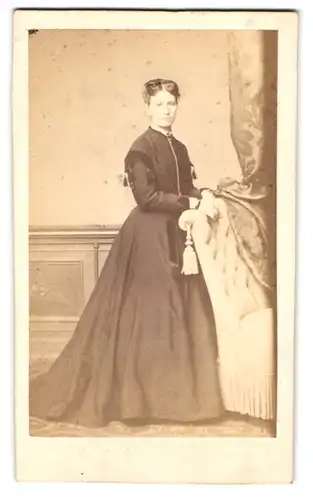 Fotografie Julius Zschille, Berlin, Neue Königs-Str. 1a, Portrait junge Frau im dunklen Kleid stehend am Sessel