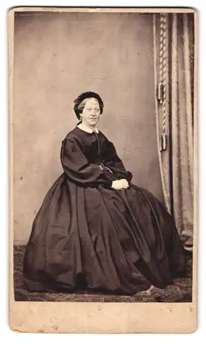 Fotografie Fototgraf und Ort unbekannt, Portrait ältere Dame im dunklen reifrock Kleid mit Haube