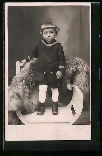 Foto-AK Kind im Matrosenanzug steht auf Stuhl mit Pelz