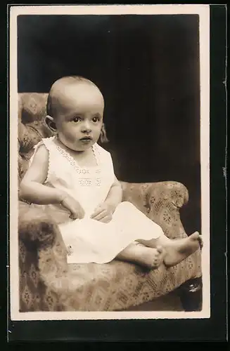 AK Kleinkind im weissen Kleidchen auf einem Sessel