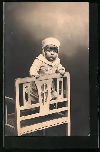 AK Kleinkind im Wintermantel posiert an einer Stuhllehne