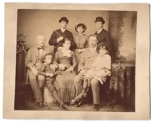 Fotografie unbekannter Fotograf und Ort, Familien-Portrait von Drei Generationen vor Studiokulisse