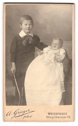 Fotografie A. Grieger, Weissensee, König Chaussee 20, Knirps in Sonntagskleidung posiert mit kleinem Geschwisterchen