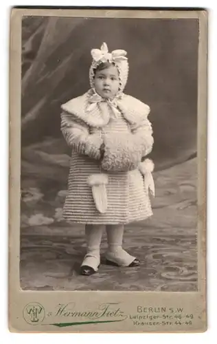 Fotografie Hermann Tietz, Berlin, Leipzigerstr. 46-49, Portrait kleines Mädchen im Winterkleid mit Muff und Haube