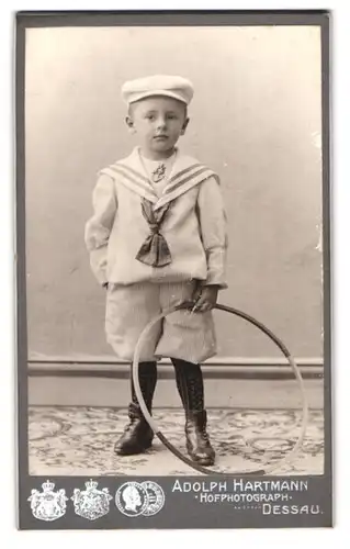 Fotografie Adolph Hartmann, Dessau, Kleiner Junge im Matrosenanzug mit Reifen