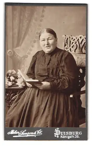 Fotografie Samson & Co., Duisburg, Königstr. 38, Ältere Dame im Kleid mit einem Buch