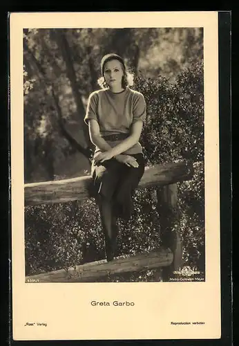 AK Schauspielerin Greta Garbo sitzt auf einem Holzzaun