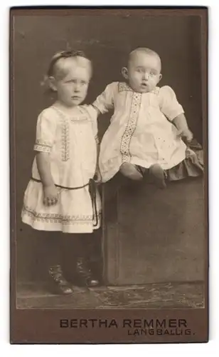 Fotografie Bertha Remmer, Langballig, Kleines Mädchen im Kleid mit einem Kleinkind