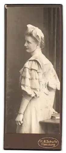 Fotografie M. B. Schultz, Flensburg, Portrait junge blonde Frau um gerafften Kleid mit Haarschleife