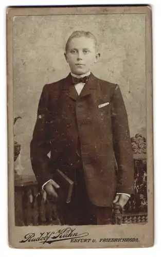 Fotografie Rudolf Kühn, Erfurt, Portrait Junge im Anzug mit Fliege und Bibel in der Hand