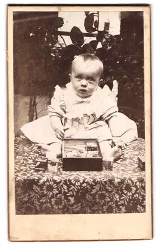 Fotografie unbekannter Fotograf und Ort, Portrait niedliches Kleinkind im karierten Kleidchen mit Bauklötzen
