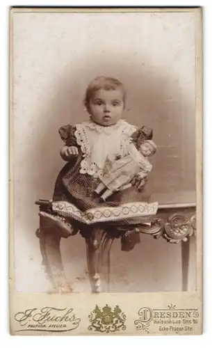 Fotografie J. Fuchs, Dresden, Waisenhaus Str. 16, kleines Mädchen im Pünktchenkleid mit ihrer Puppe im Arm