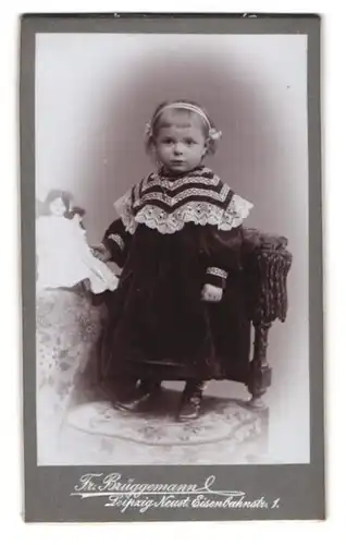 Fotografie Fr. Brüggemann, Leipzig, Eisenbahnstr. 1, blondes Mädchen im Samtkleid mit ihrer schwarzhaarigen Puppe