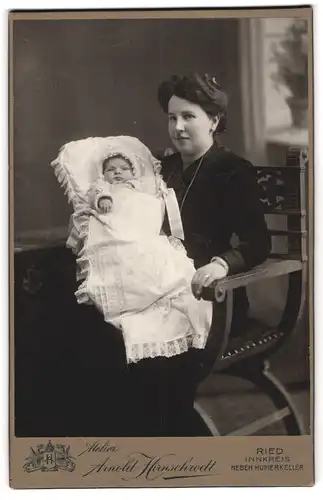 Fotografie Arnold Hirnschrodt, Ried, Mutter im Samtkleid mit ihrem Neugeborenem im Wickelgewand