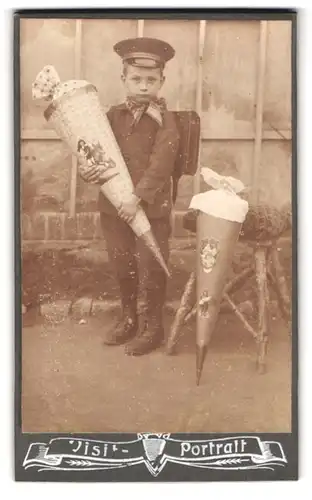 Fotografie unbekannter Fotograf und Ort, Portrait junger Knabe in Schuluniform mit zwei grossen Zuckertüten