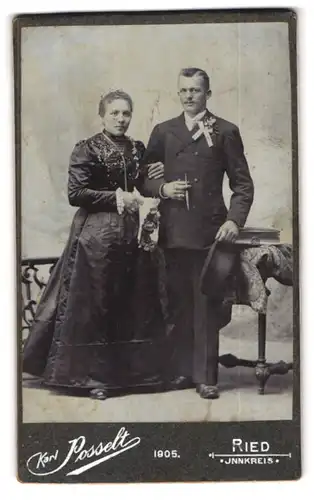 Fotografie Karl Posselt, Ried, Brautpaar im schwarzen Kleid und Anzug mit Hut und Zigarre