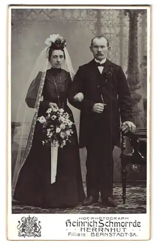 Fotografie Heinrich Schmirrde, Herrnhut, Brautpaar im schwarzen Hochzeitskleid und Schleier posieren im Atelier