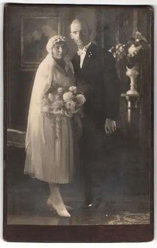 Fotografie Rich. Wörsching, Starnberg, Portrait Brautleute im Hochzeitskleid und Anzug mit Zylinder