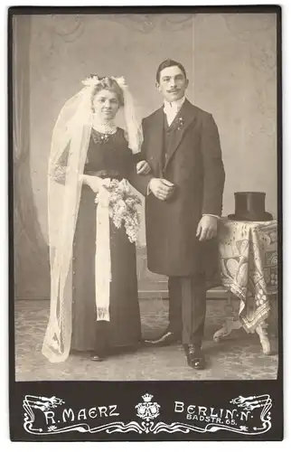 Fotografie P. Maerz, Berlin, Badstr. 65, junges Brautpaar im schwarzen Hochzeitskleid und Anzug nebst Zylinder