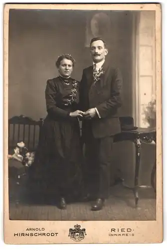 Fotografie Arnold Hirnschrodt, Ried, Portrait Eheleute im schwarzen Hochzeitskleid und Anzug mit Ansteckblumen