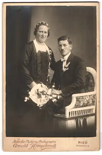 Fotografie Arnold Hirnschrodt, Ried, Portrait Eheleute im schwarzen Hochzeitskleid und Anzug mit Brautstrauss