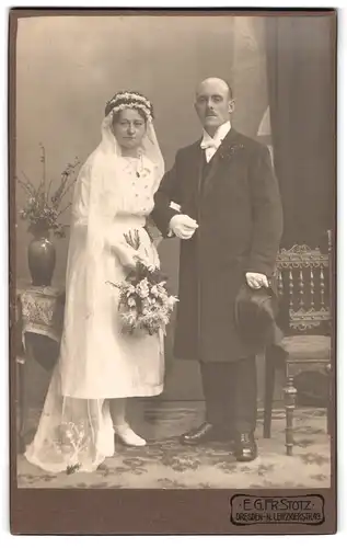 Fotografie E. G. Fr. Stotz, Dresden, Leipzigerstr. 49, Brautleute im Hochzeitskleid und Anzug mit Zylinder posieren