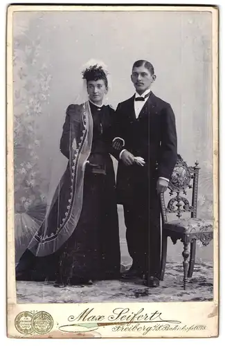 Fotografie Max Seifert, Freiberg i. S., Bahnhofstr. 18, junge Brautleute im schwarzen Hochzeitskleid mit Schleier, Anzug